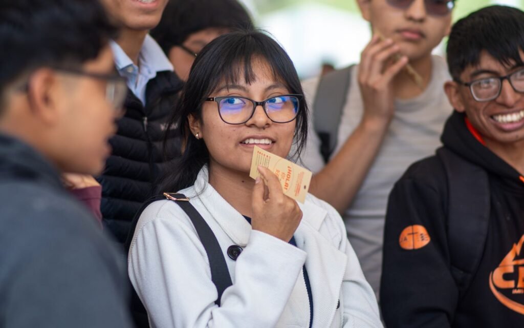 Group of university students socializing outdoors at a campus event in Piura, Peru, showcasing modern youth culture.